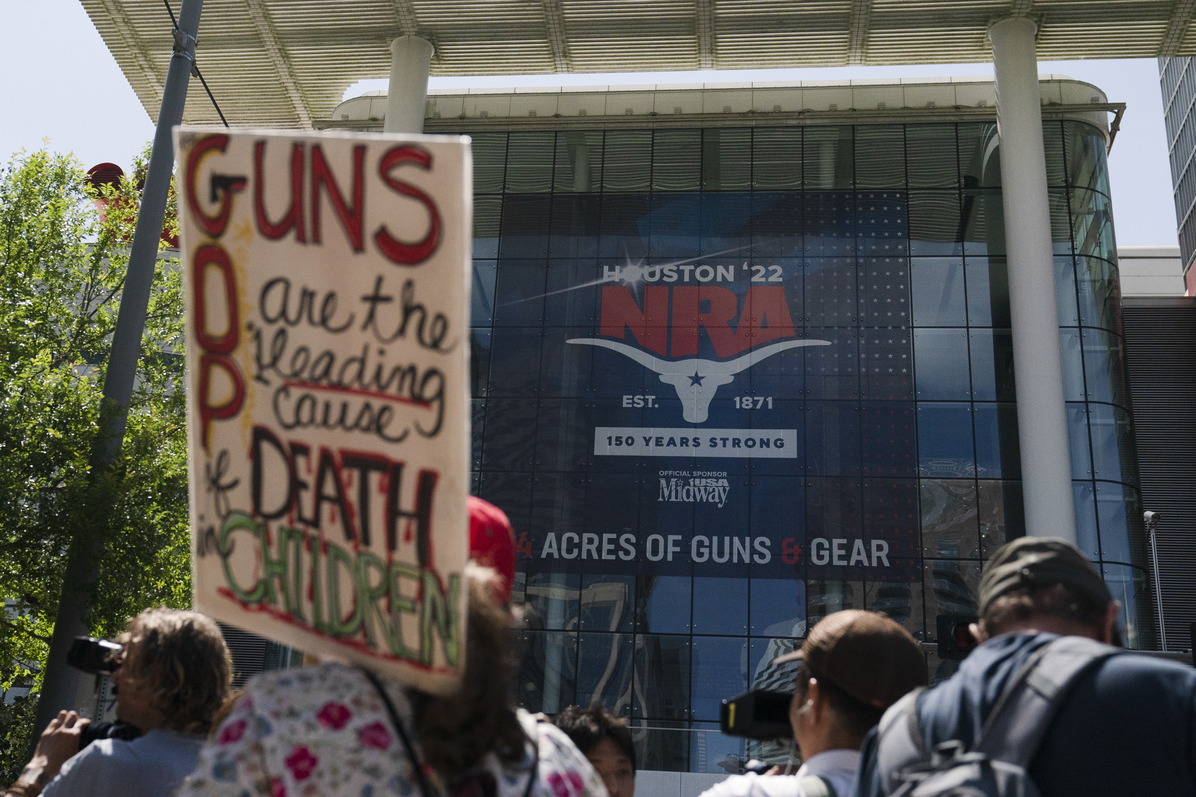 People gather outside the George R. Brown Convention Center to protest the National Rifle Association's annual meeting in Houston, Friday, May 27, 2022. (AP Photo/Jae C. Hong)