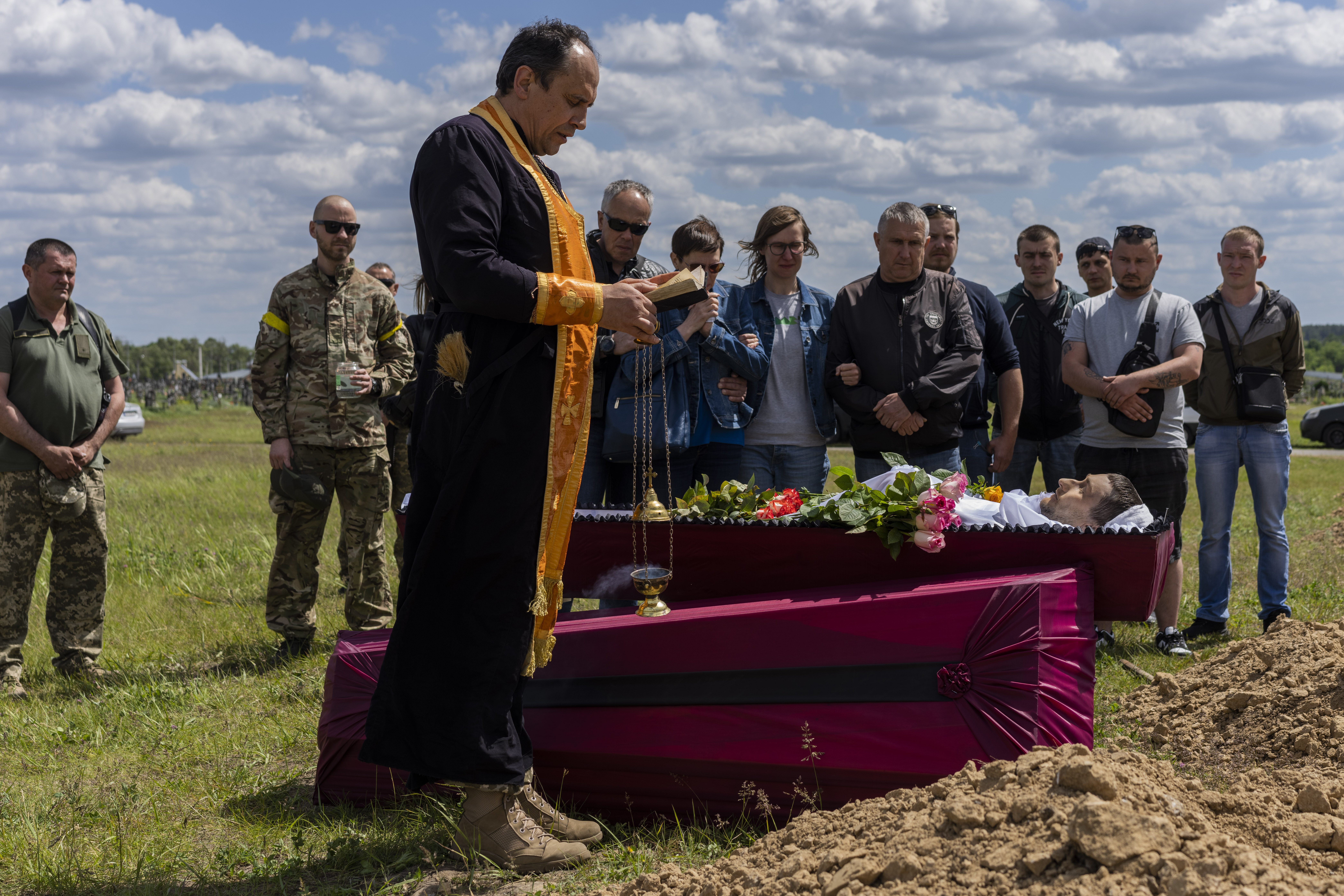 Relatives and friends attend the funeral of Ukrainian serviceman Vitaliy Nejenits in Kharkiv cemetery, eastern Ukraine, Friday, May 27, 2022. (AP Photo/Bernat Armangue)