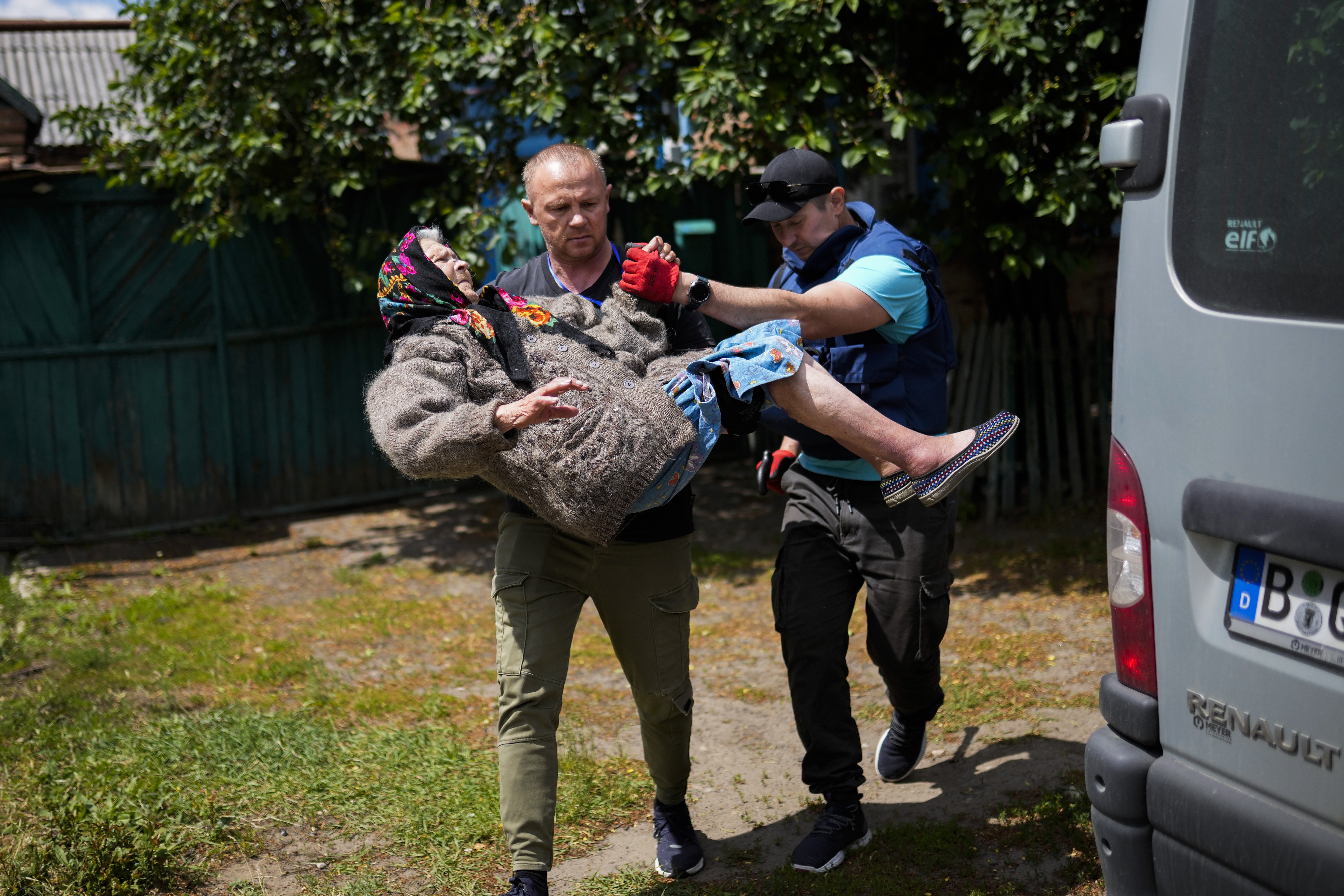 A woman is carried from her home in an evacuation by volunteers of Vostok SOS charitable organisation in Bakhmut, eastern Ukraine, Friday, May 27, 2022. Volunteers have been racing to evacuate as many civilians as possible, particularly the elderly and those with mobility issues, as Russian forces make advances in the region. (AP Photo/Francisco Seco)