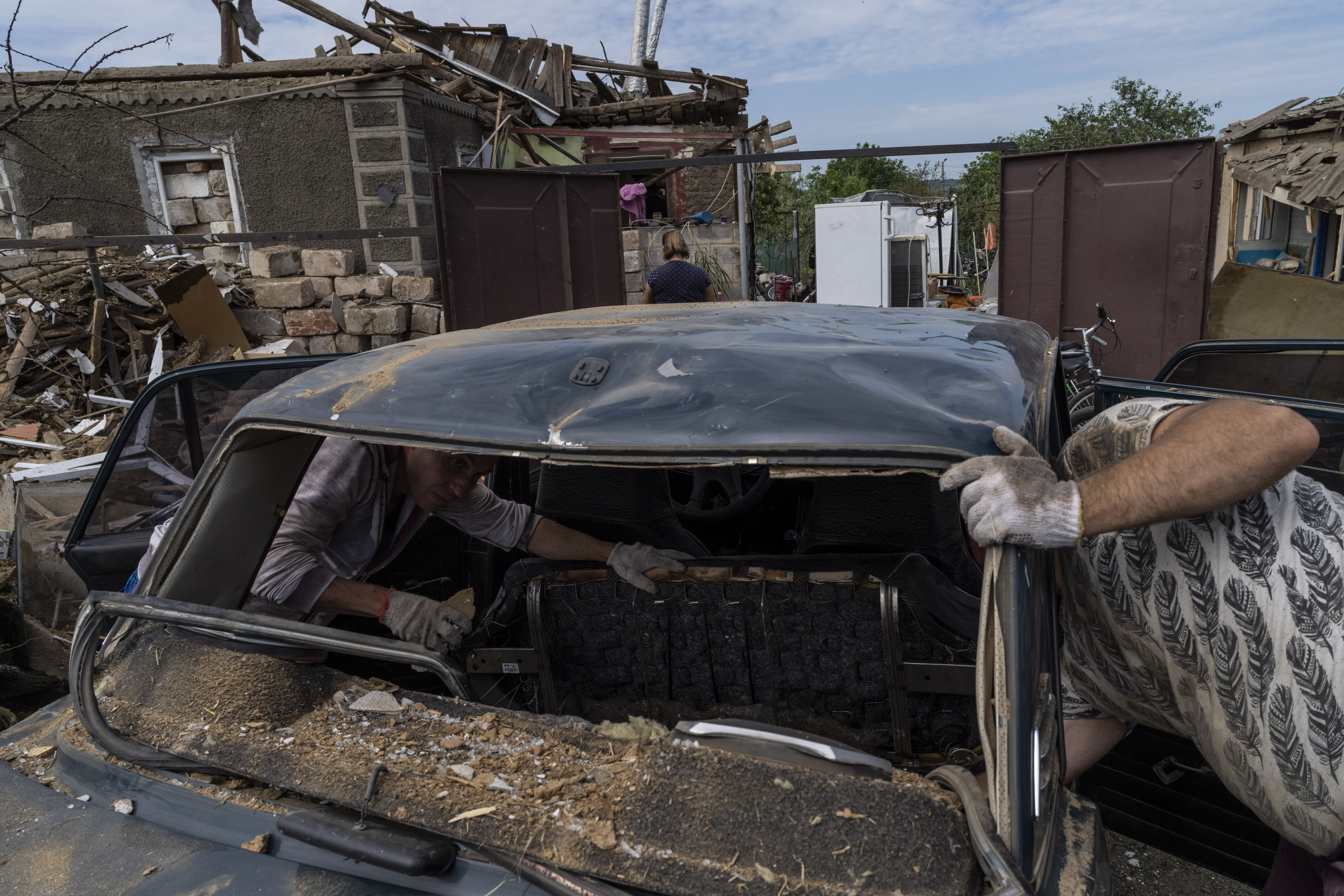 Residents inspect damages after a missile strike in Druzhkivka, eastern Ukraine, Sunday, June 5, 2022. (AP Photo/Bernat Armangue)